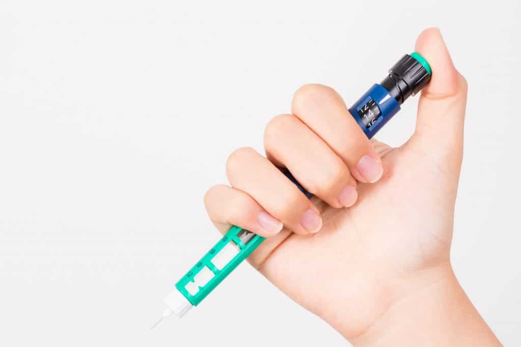 a hand holds an insulin pen - people wonder about the Basaglar Kwikpen vs Tempo Pen.