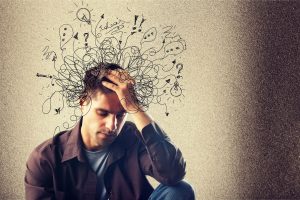 a man holds his head with scribbles around his head. Those who have ADHD but do not take ADHD medication may feel this way every day.